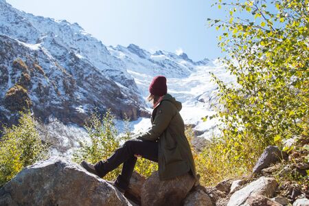 Travel woman sitting on the top and looking at the snowy mountains of Alibek glasier in sunny day in...