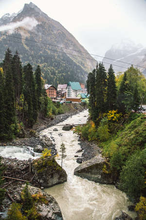 Dombay ski resort in autumn season, view on Amanaus river and beautiful mountains landscape from the bridge in village, Caucasus, Russiaの写真素材