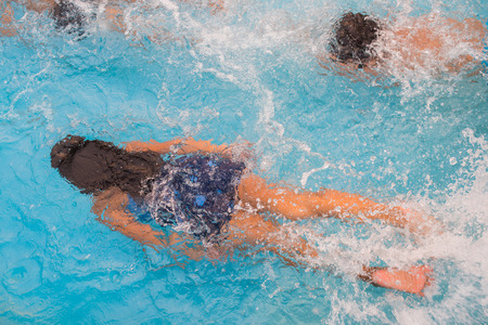 Children swim in pool underwater, happy active girls have fun in waterの写真素材
