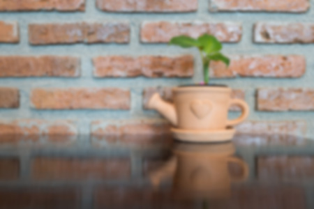 Blur tree in pot on wooden table and stone background.の写真素材