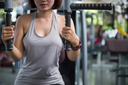 Young beautiful woman doing exercises in fitness gym.の写真素材