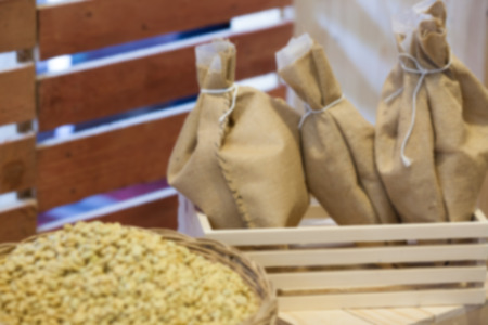 Coffee beans in sack bag on brown wooden background,blurry background.の写真素材