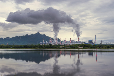 Industrial power plant with smokestack near the river.の写真素材