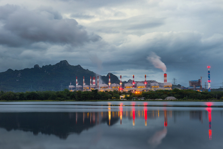 Industrial power plant with smokestack near the river.の写真素材
