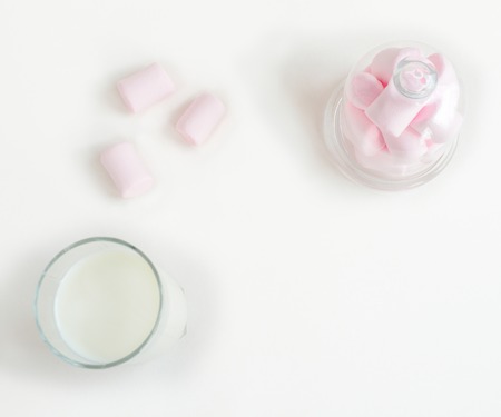 Template with glass of milk and pink marshmallow on white backgroundの写真素材