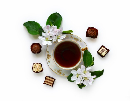 Retro Cup of tea with chocolates and apple blossom isolated on white backgroundの写真素材