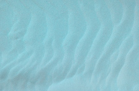 Beach blue sand background. Close up texture with unusual sea sandの写真素材
