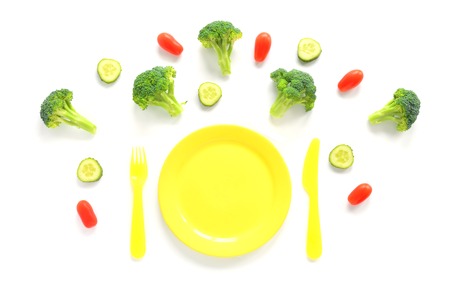 Broccoli, tomatoes and cucumbers with plate. Top View isolated on white background. Vegetarian flat lay.の写真素材