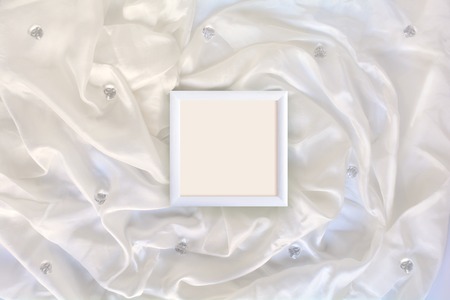 Wood frame on white silk with crystals. Flat lay composition for art works, greeting, wedding, birthday cardsの写真素材