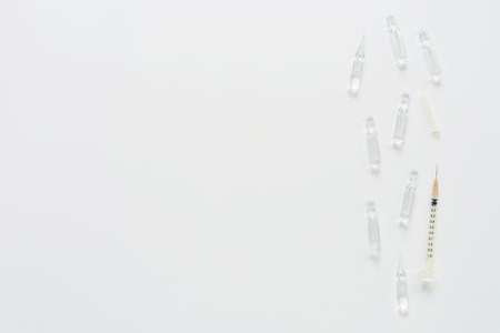 Medical composition with syringe and ampules on white background. Top view of doctor workplace. Vertical flat lay mock up.の写真素材