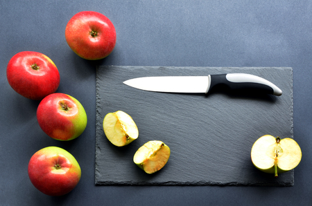 Flat Lay with apples, knife, black stone cutting board.の写真素材