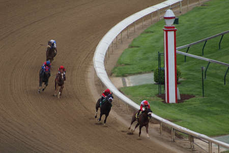LOUISVILLE, KENTUCKY - APRIL 28, 2021: Horses come around final turn in a claiming race at Churchill...