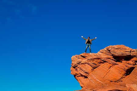 Man standing on the edge of the rockの写真素材