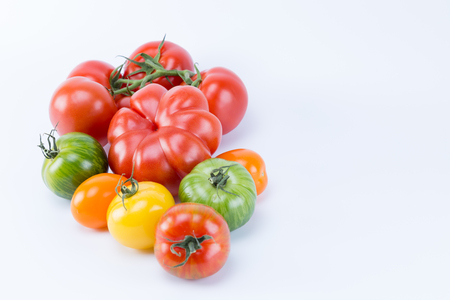 Different colors and shapes tomatoes isolated on white background. Liked by branch.の写真素材