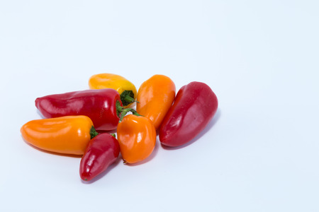 Different sorts and colors of fresh mini bell pepper isolated on white backgroundの写真素材