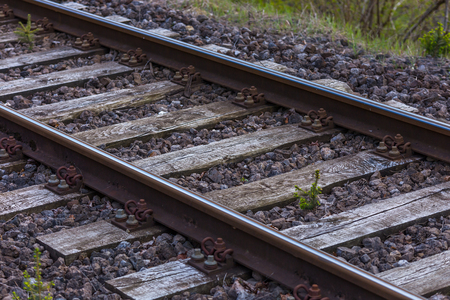 Close up on old wood train tracks with small stones, rusty screws and nuts.の写真素材