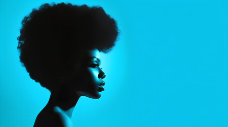 Beautiful african american woman with curly hair on blue backgroundの素材