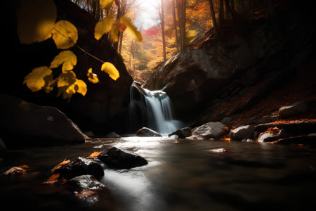 Autumn landscape with a waterfall in the forest. Colorful leaves on the rocks.の素材
