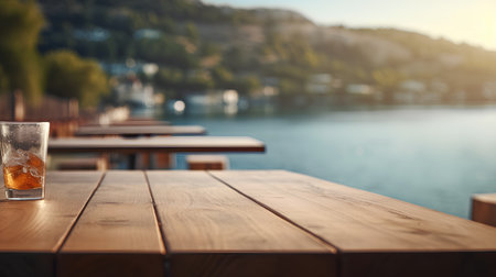 A glass of whiskey on a wooden table in front of the sea.の素材