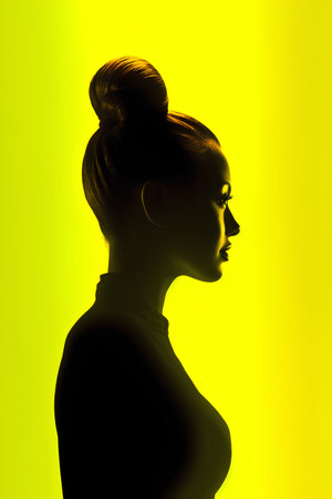 Silhouette of a beautiful woman in profile on a yellow backgroundの素材
