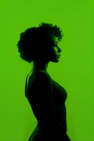 Silhouette of a beautiful african american woman on green backgroundの素材