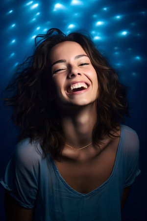 Portrait of a beautiful young woman on a blue background with lightsの素材