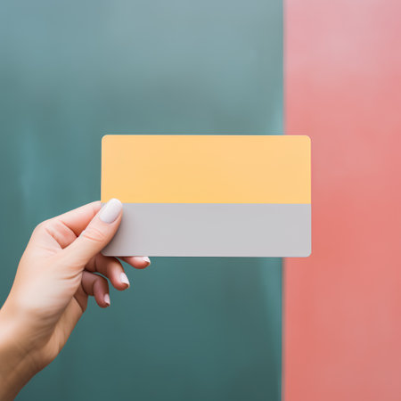 Woman hand holding credit card over red and green background with copy spaceの素材