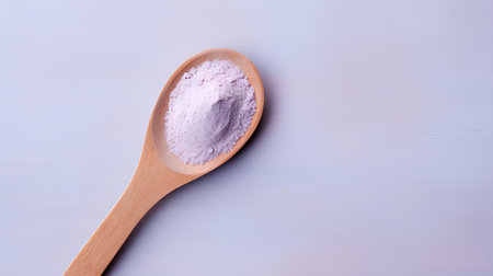 Powdered salt in a wooden spoon on a blue backgroundの素材
