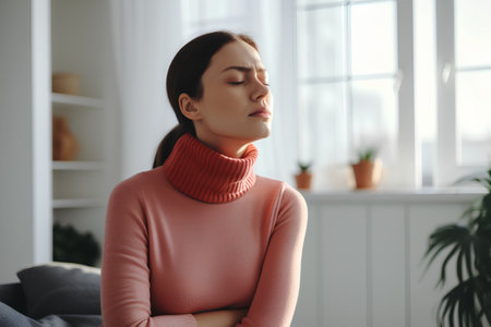 Beautiful young woman in a pink sweater is resting at home.の素材