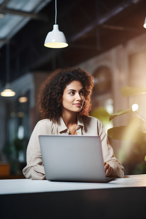 Attractive african american businesswoman using laptop while sitting in officeの素材