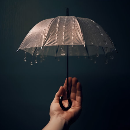 Female hand holding transparent umbrella with raindrops on dark background, closeupの素材