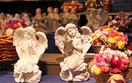 Angels playing on musical instruments on the background of baskets with flowersの写真素材