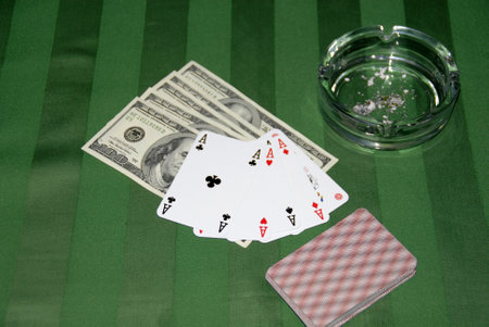 Play cards, money and ash-tray on a green tableclothのeditorial素材