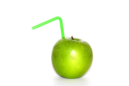 Isolated green apple with a coctail straw on a white backgroundの写真素材
