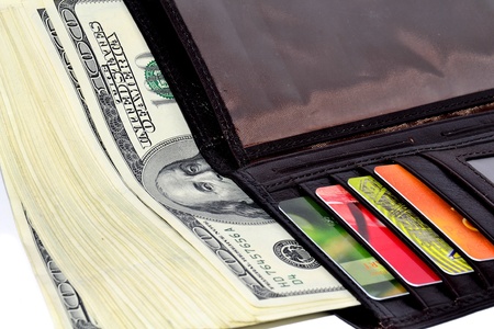 Wallet with money and credit cards close-up isolated on white