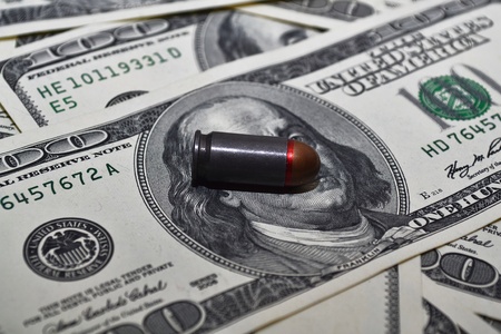 Bullet closeup over the dollar surface (focus on bullet)の写真素材