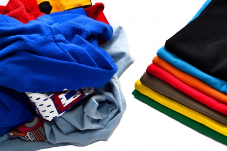 Stack of folded and clean shirts vs pile of dirty clothesの写真素材