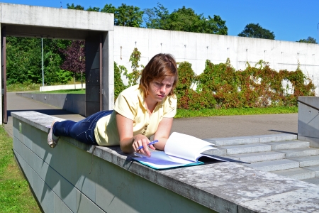 Student girl resting near the university with her notesの写真素材