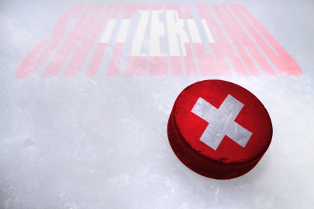 Vintage old hockey puck with the Switzerland flag is on the iceの写真素材
