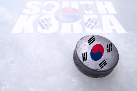Vintage old hockey puck with the South Korea flag is on the iceの写真素材