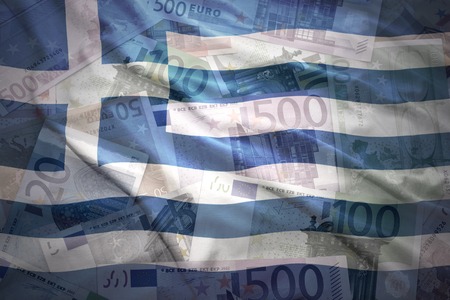 colorful waving greek flag on a euro money backgroundの写真素材