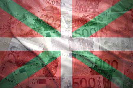 colorful waving basque country flag on a euro money backgroundの写真素材