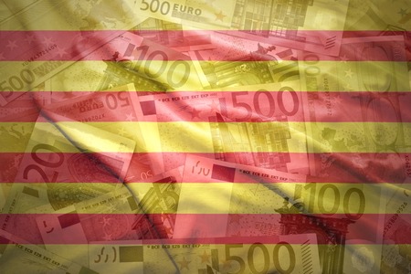 colorful waving catalonia flag on a euro money backgroundの写真素材