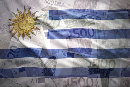 colorful waving uruguayan flag on a euro money backgroundの写真素材