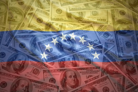 colorful waving venezuelan flag on a american dollar money backgroundの写真素材