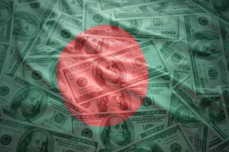 colorful waving bangladeshi flag on a american dollar money backgroundの写真素材