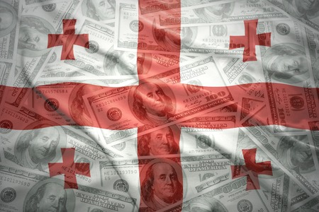 colorful waving georgian flag on a american dollar money backgroundの写真素材