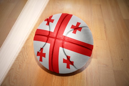 basketball ball with the national flag of georgia lying on the floor near the white lineの写真素材