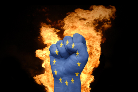 fist with the flag of european union near the fire on a black backgroundの写真素材
