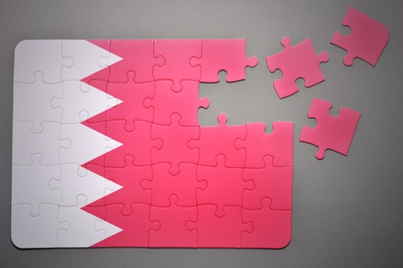 broken puzzle with the national flag of bahrain on a gray backgroundの写真素材